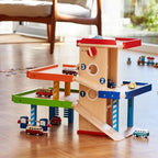 Wooden toy track with colorful ramps and toy cars on a wooden floor.