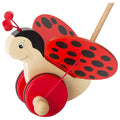 Wooden ladybug pull toy with red and black design on a white background